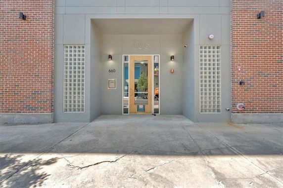 Front view of a building entrance with brick and glass block walls.