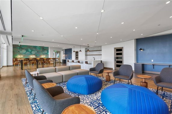 Spacious clubhouse interior with modern furniture and bar area.