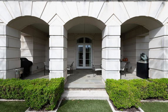 Front view of a building with arches and a small patio area.