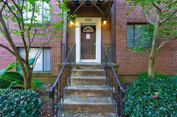 Front view of a brick building entrance with steps leading up to a door.