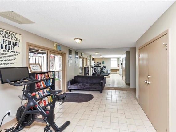 Indoor recreation area with exercise equipment and seating.