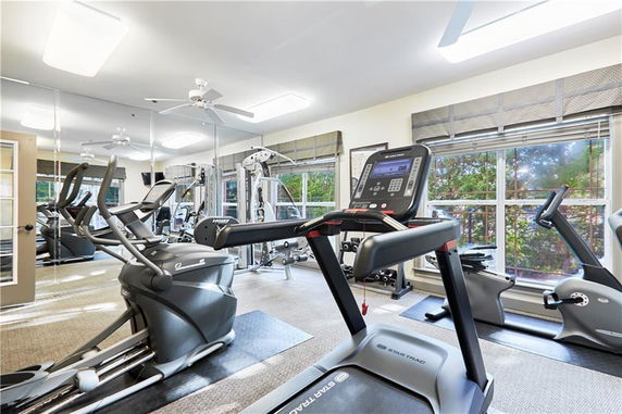 Indoor gym area with exercise equipment including treadmills and stationary bikes.