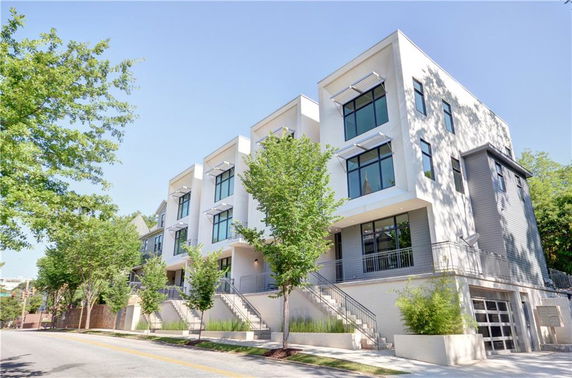 Front view of a modern multi-story building with large windows and balconies.