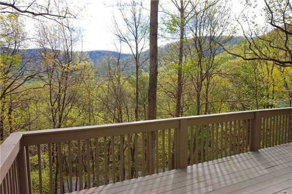 Panoramic view of a forested area from a wooden balcony.
