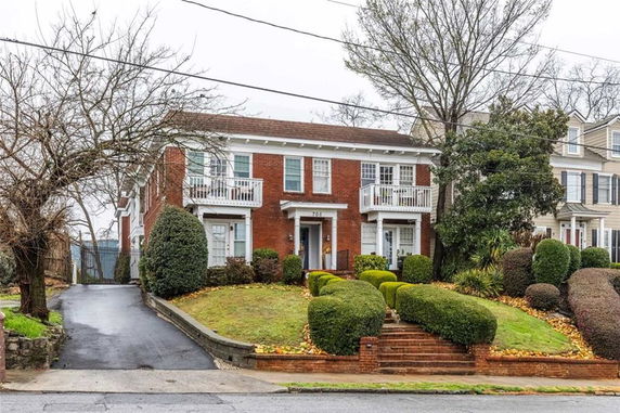 Front view of a two-story brick house with balconies.