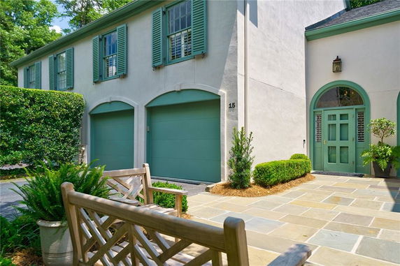 Front view of a house with double garage doors and green shutters.