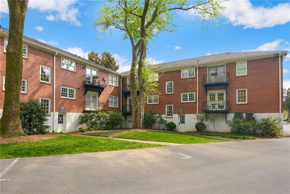 Front view of a multi-story brick building with balconies.