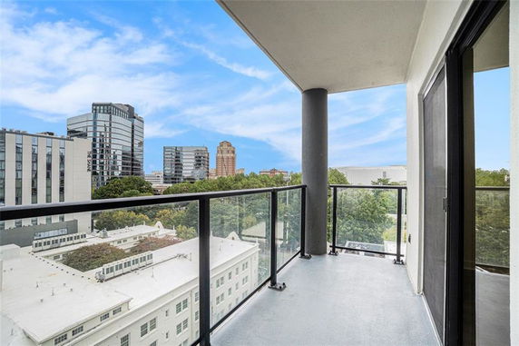 View from a balcony overlooking surrounding buildings and a blue sky.