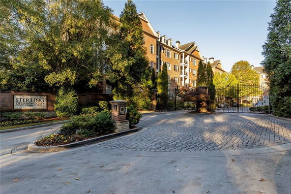 Front view of a multi-story building with brick exterior and gated entrance.