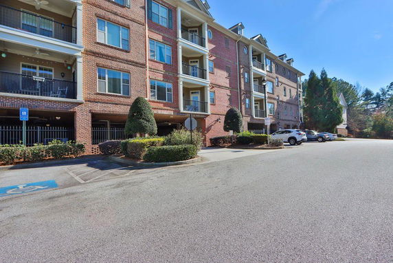 Front view of a multi-story brick apartment building with balconies.