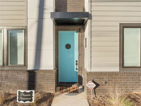 Front view of a house entrance with a blue door and modern design elements.