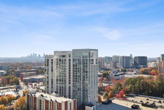 Aerial view of a city skyline with tall buildings and autumn-colored trees.