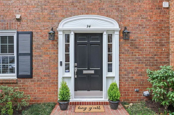 Front view of a brick house with a black door and white trim.