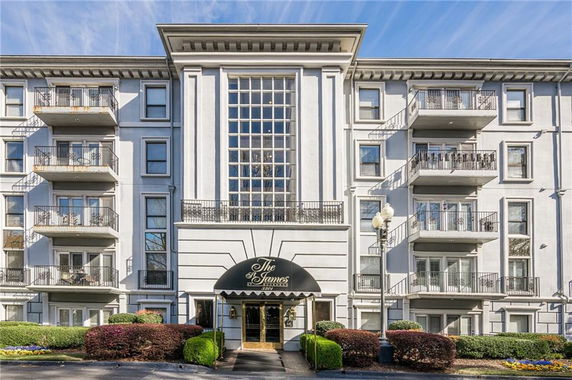 Front view of a multi-story building with balconies and a central entrance.