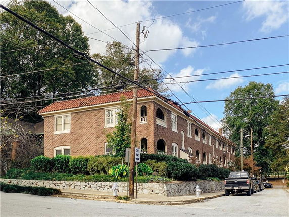 Front view of a two-story brick building with a red tile roof.