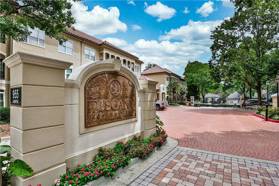 Front view of a residential building with a sign reading 'Tuscany Condominiums'.