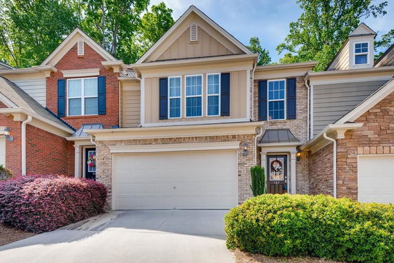 Front view of a two-story townhouse with a double garage and brick facade.