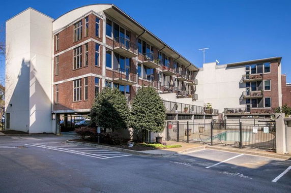 Front view of a multi-story brick building with balconies.
