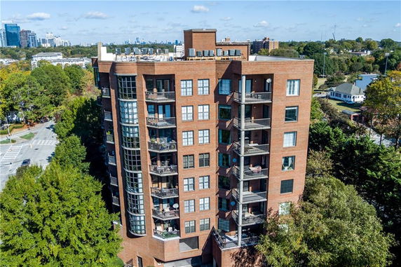 Front view of a multi-story brick apartment building with several balconies.