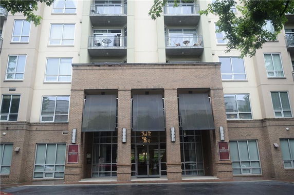 Front view of a multi-story building with balconies and large windows.