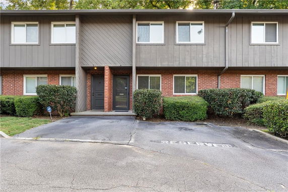 Front view of a two-story townhouse with a brick and wood exterior.