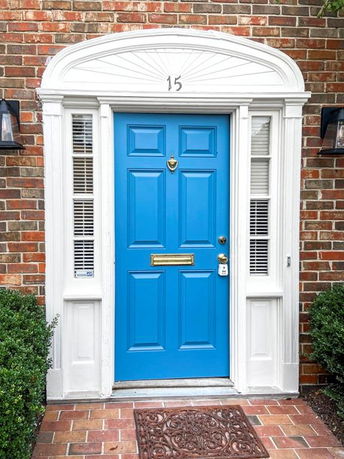 Front view of a house with a prominent blue door and brick exterior.