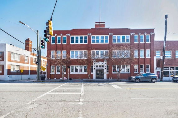 Front view of a three-story brick building with multiple windows and a central entrance.