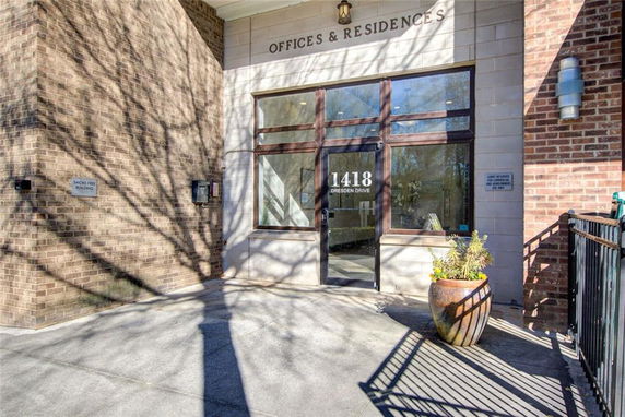 Entrance of a building with a glass door and brick facade labeled Offices & Residences.