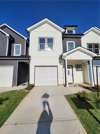 Front view of a modern two-story house with a garage and white facade.