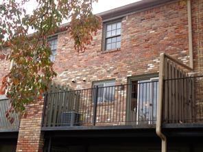 Front view of a brick two-story building with a balcony.