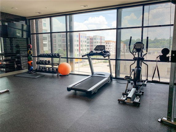 Indoor gym area with exercise equipment and large windows.