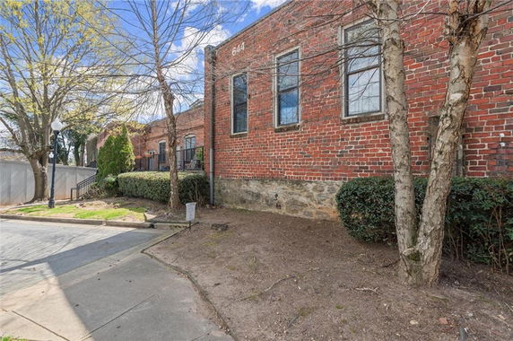 Front view of a brick building with large windows and a numbered address.