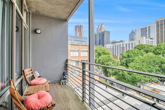 View from a balcony overlooking city buildings and greenery.