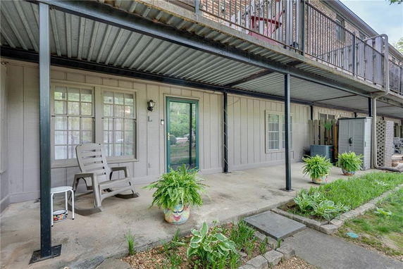 Front view of a house with a covered patio and potted plants.