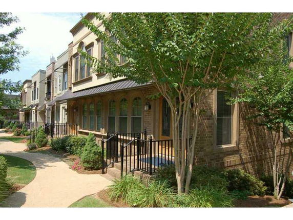 Front view of a row of townhouses with landscaped walkway.