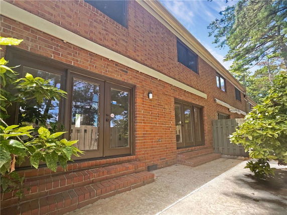 Exterior view of a two-story brick building with multiple windows and a glass door entrance.
