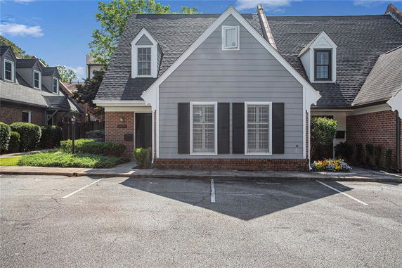 Front view of a house with a steep roof and dormer windows.