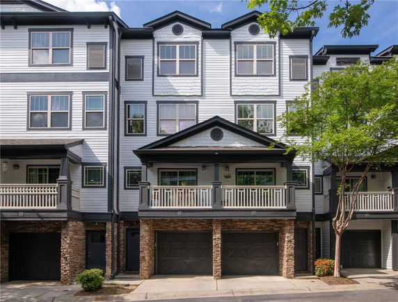 Front view of a multi-story townhouse with multiple garages and balconies.