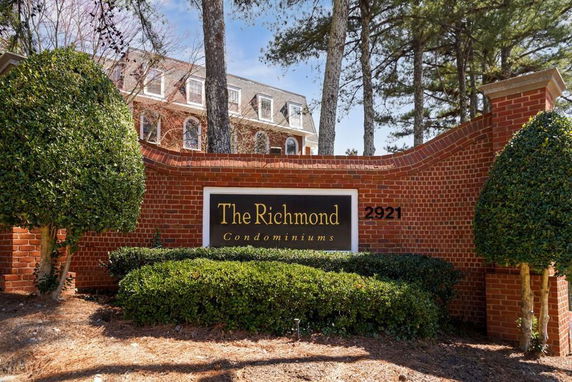 Front view of a condominium named The Richmond with brick facade and trees.