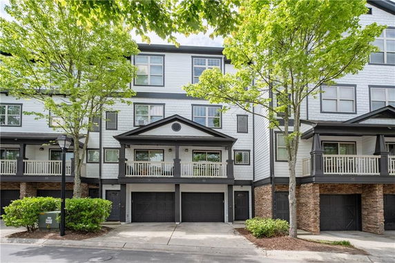 Front view of a multi-story townhouse with attached garage.
