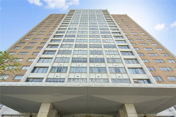 Front view of a tall high-rise building with multiple windows and a prominent entrance.