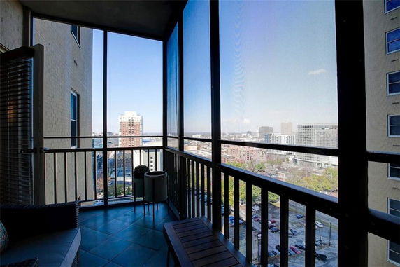 Enclosed balcony with a view of city buildings.
