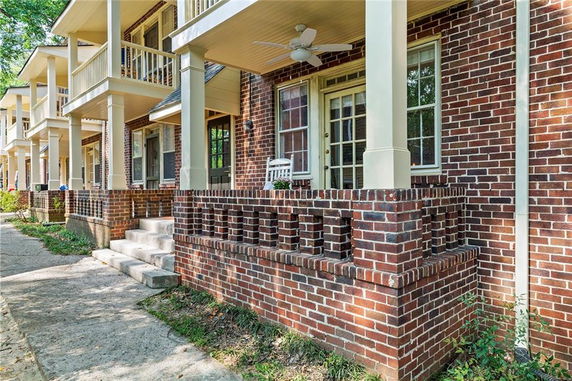 Front view of a two-story building with a brick facade and columned porch.