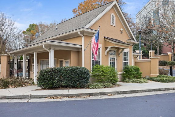 Front view of a house with a gable roof and a flagpole.