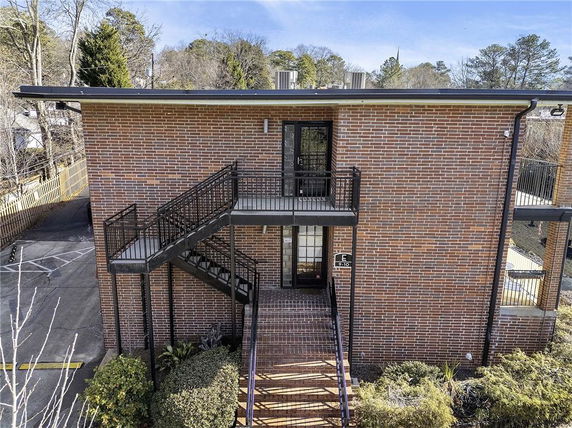 Front view of a two-story brick building with external staircase.