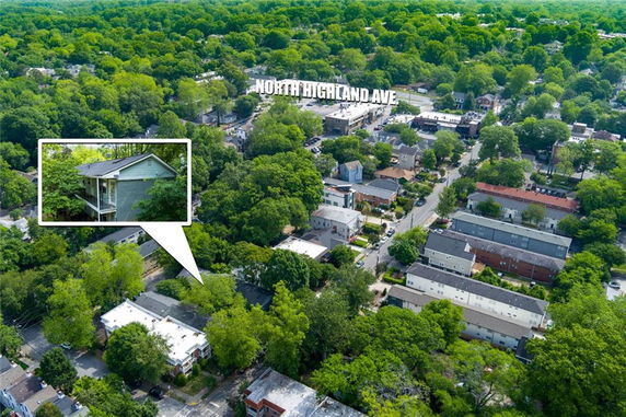 Panoramic aerial view of a residential neighborhood surrounded by trees.