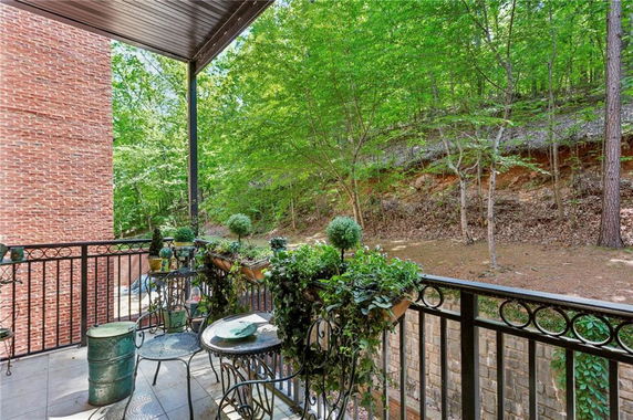 View from a balcony with metal railing overlooking a wooded area.