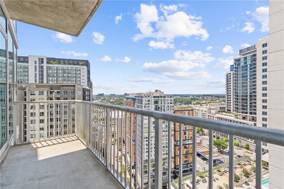 View from a high-rise balcony overlooking city buildings and skyline.
