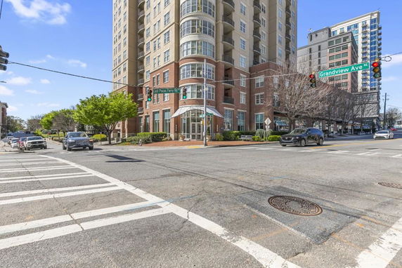 Front view of a tall residential building at a street intersection.