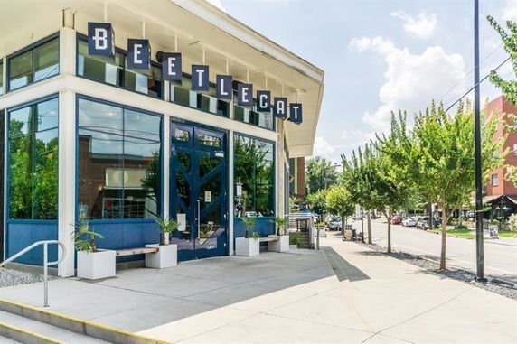 Front view of a modern building with large windows and distinctive signage.